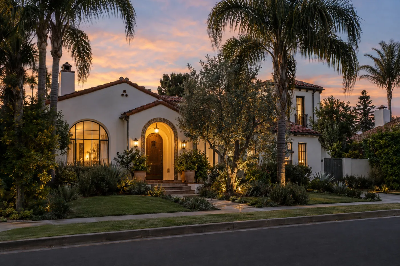 Restored Spanish revival home lit at dusk on a quiet Los Angeles street
